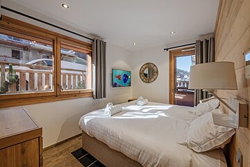 A bedroom with two beds and a flat screen tv
