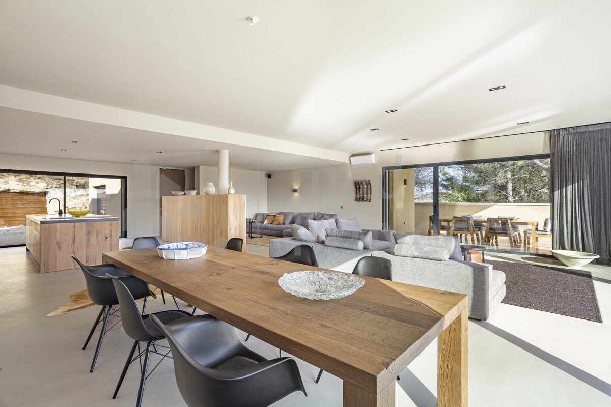 A living room with a wooden table and black chairs