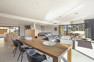 A living room with a wooden table and black chairs