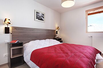 A bedroom with a bed and a picture on the wall