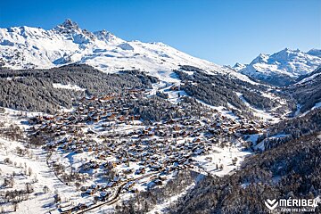 An aerial view of a snowy valley with the word meribel on the bottom