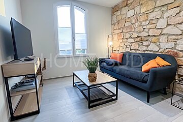 A living room with a couch and a tv and the word home on the wall