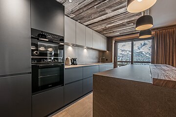 A kitchen with black cabinets and a siemens oven
