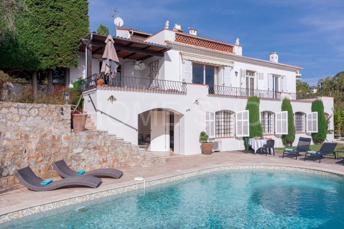 A large white house with a swimming pool in front of it