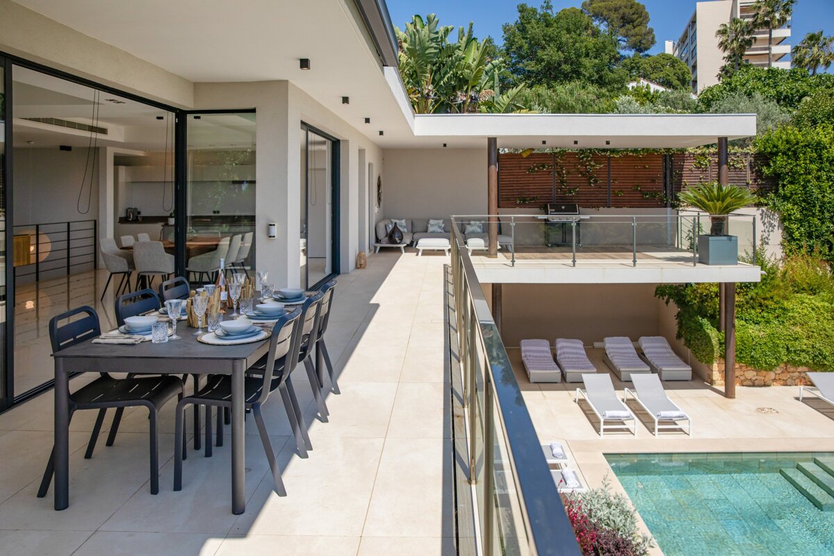 A table and chairs on a balcony overlooking a pool