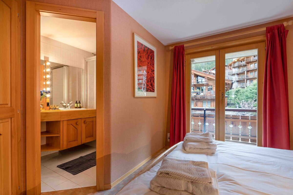 A bedroom with a large bed and a bathroom