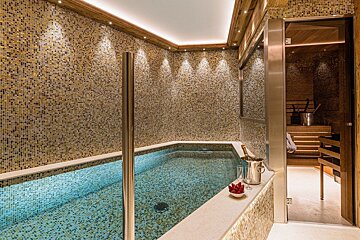 A swimming pool with a bottle of champagne on the edge