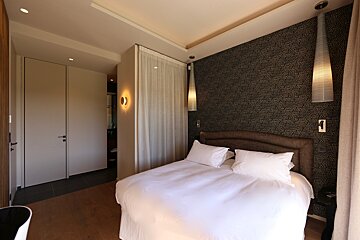 A bedroom with a bed and a black and white wallpaper