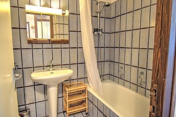 A bathroom with a sink and a bathtub with a shower curtain