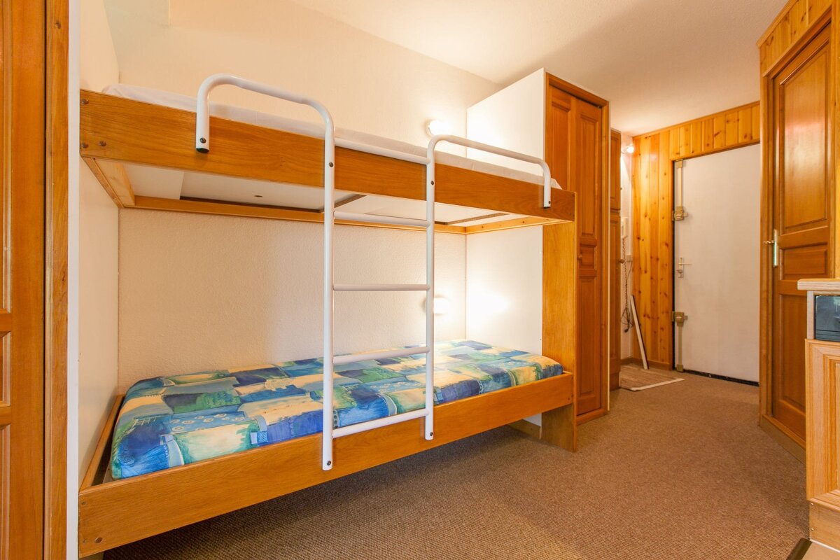 A bunk bed with a blue and yellow blanket on it