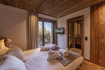A bedroom with a bed and two pictures on the wall