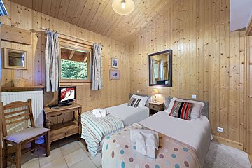 A bedroom with two twin beds and a flat screen tv