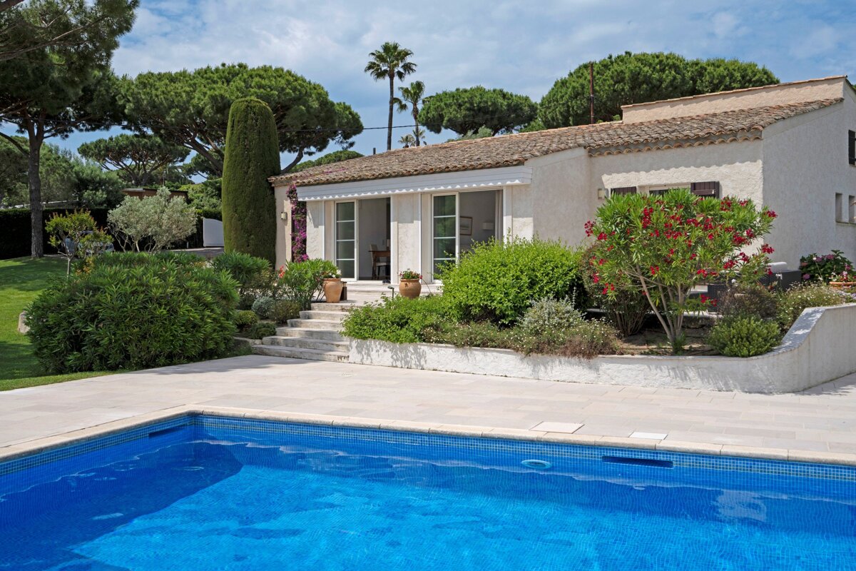 A house with a swimming pool in front of it