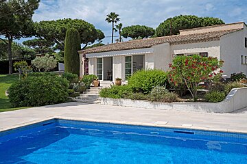 A house with a swimming pool in front of it