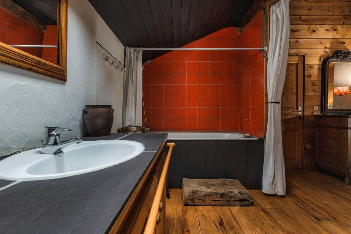 A bathroom with red tiles and a white curtain