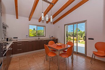 A kitchen with a table and chairs and a sliding glass door