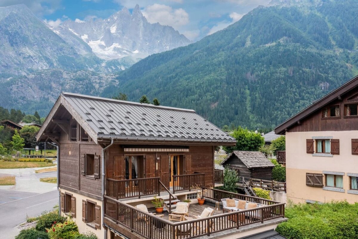 A house with a balcony and mountains in the background