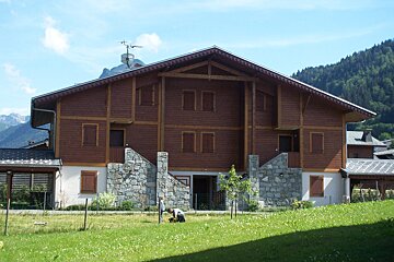 A large wooden house with a roof that has a antenna on top of it