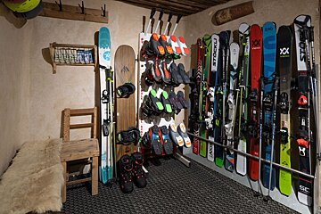 A bunch of skis and snowboards including one that says stocku