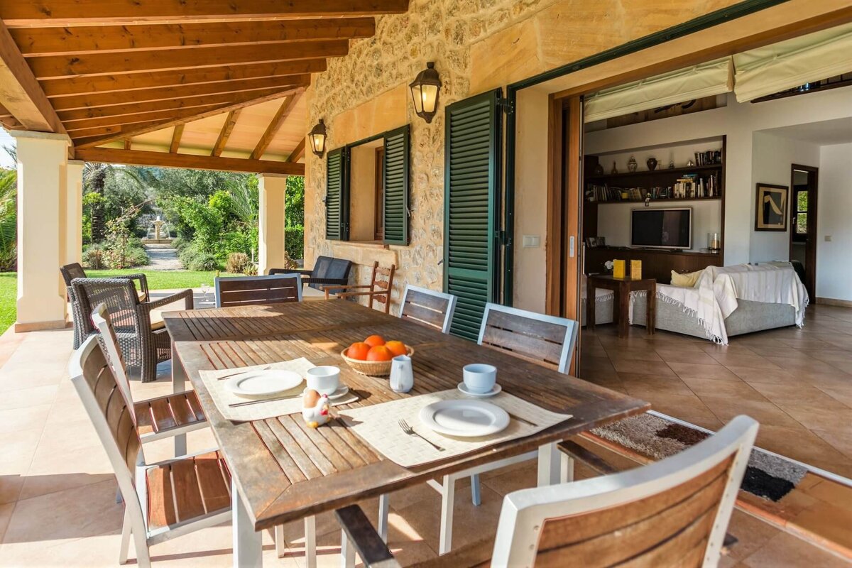 A table with plates and a bowl of oranges on it
