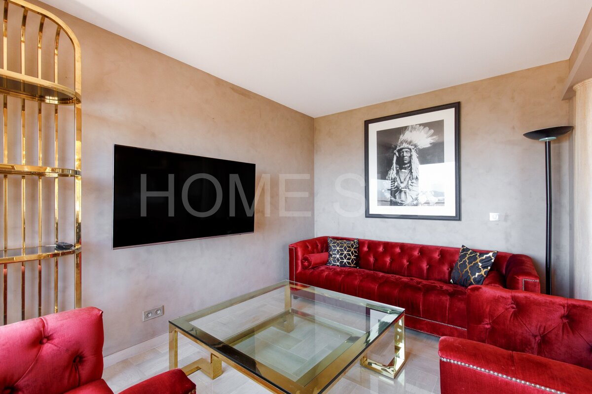 A living room with red furniture and a television that says home on it