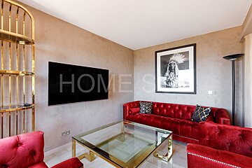 A living room with red furniture and a television that says home on it