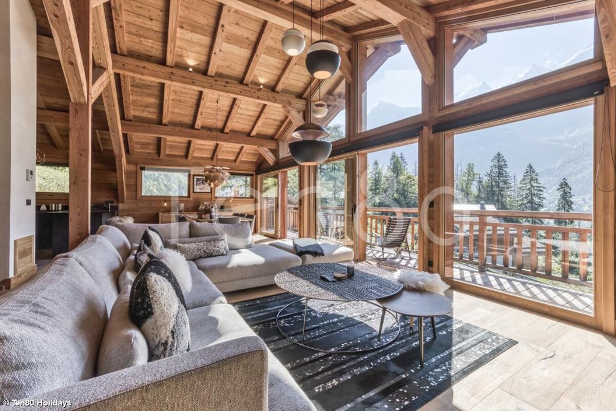 A living room with a large couch and lots of windows