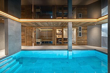 A swimming pool with a sauna in the background