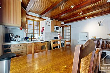 A kitchen with a wooden table and chairs and the word alpine on the bottom