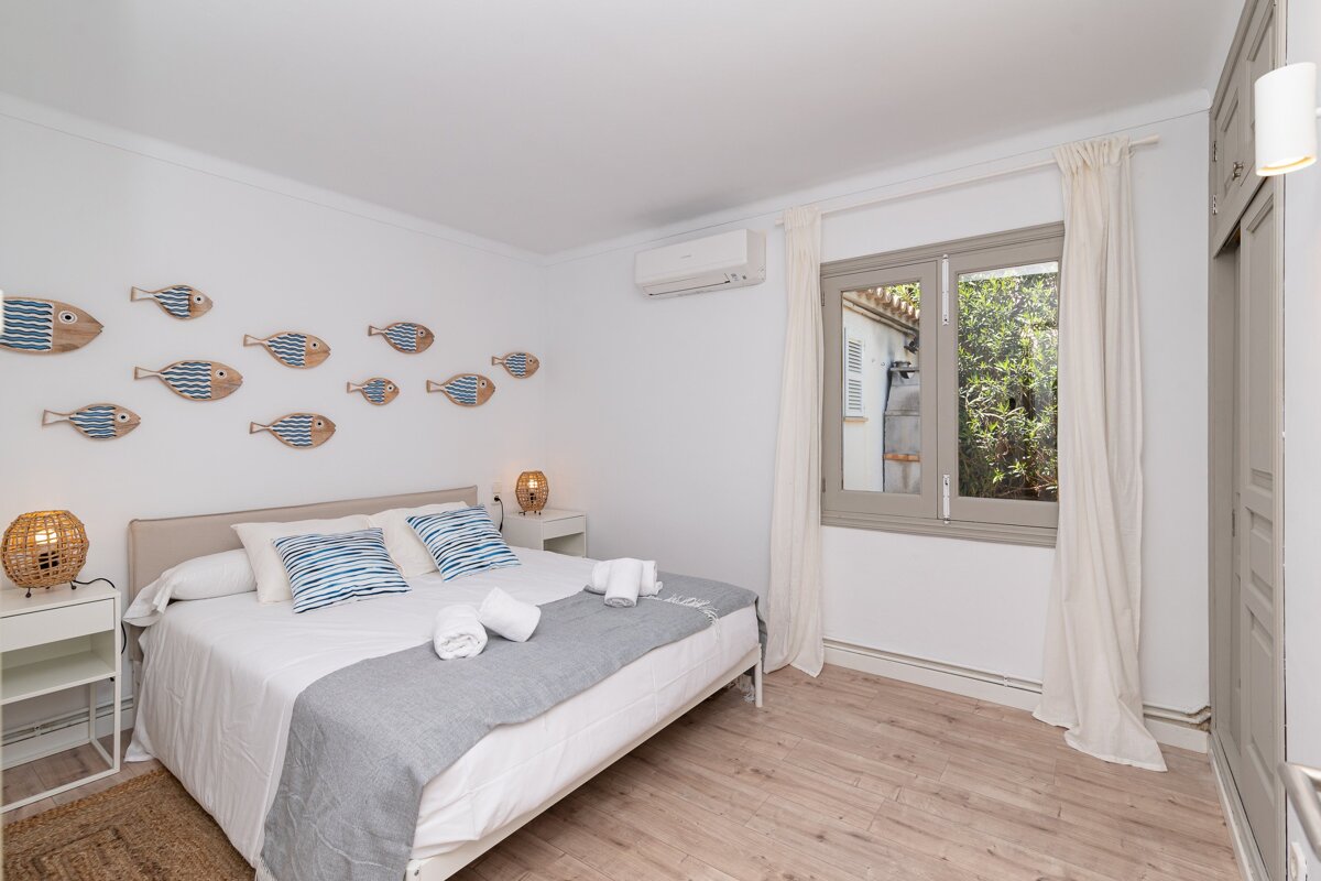 A bedroom with a bed and fish on the wall