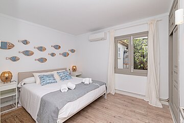 A bedroom with a bed and fish on the wall