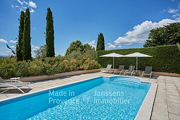 A large swimming pool is surrounded by chairs and umbrellas made in provence