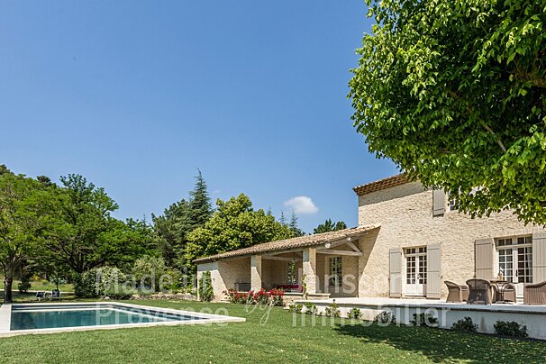 A large brick house with a large swimming pool in front of it
