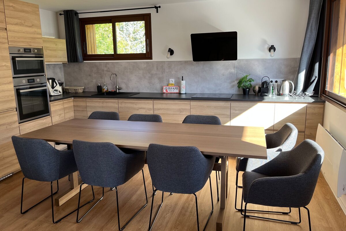 A kitchen with a table and chairs and a sign on the wall that says ' coca cola '