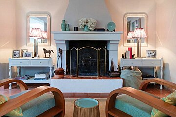 A living room with a fireplace and two chairs