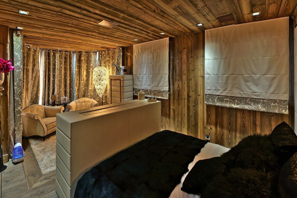 A bedroom with wooden walls and a black bed