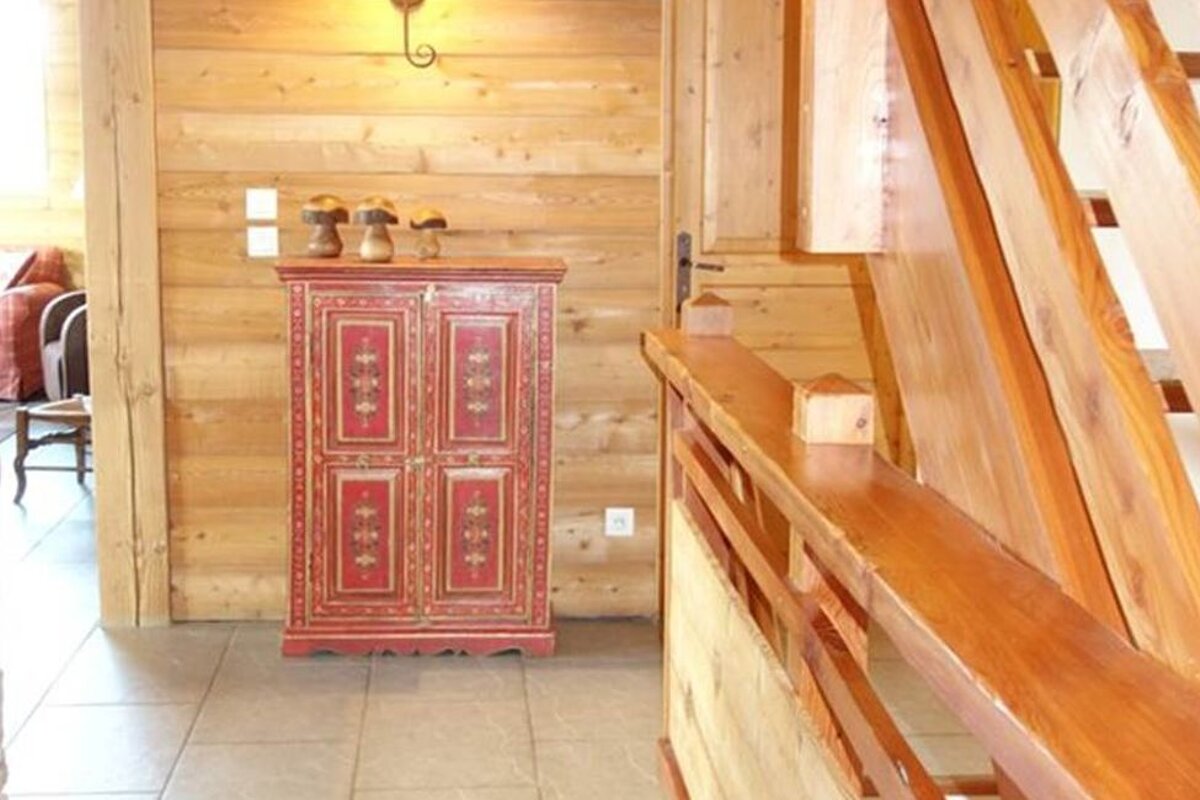 A wooden hallway with a red cabinet and stairs