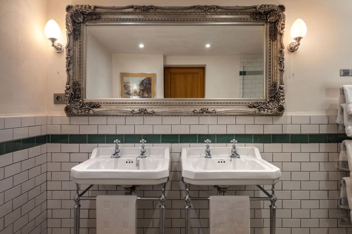 A bathroom with two sinks and a large mirror