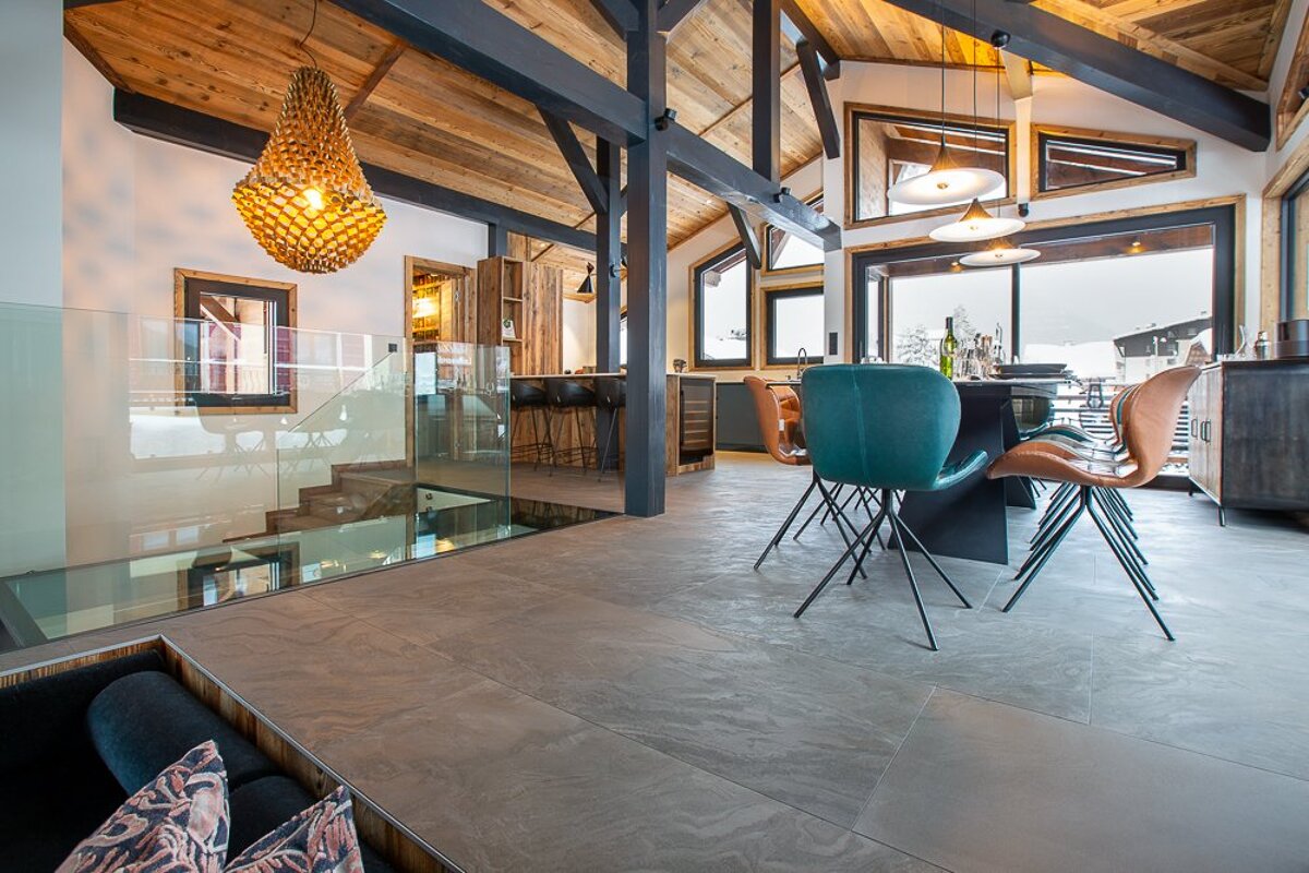 A dining room with a table and chairs and a large window