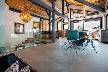 A dining room with a table and chairs and a large window