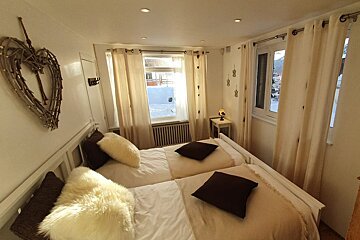 A bedroom with two beds and a heart on the wall