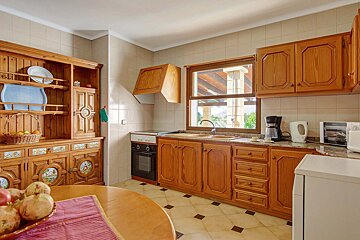 A kitchen with wooden cabinets and a microwave