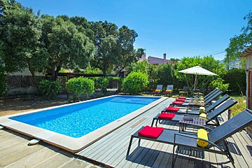 A large swimming pool surrounded by chairs and umbrellas