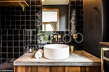 A bathroom with black tiles and a white sink