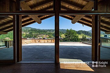 A room with a view of the mountains and the words mountain base immobilie real estate