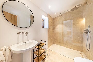 A bathroom with a sink and a walk in shower