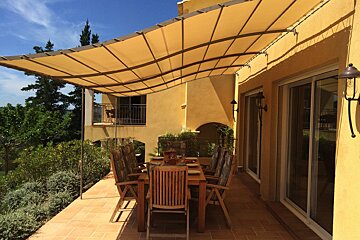 A patio with a table and chairs under an awning