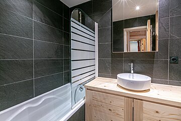 A bedroom with a bed and a poster on the wall that says val d' isere
