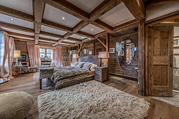 A bedroom with a large bed and a rug