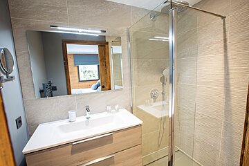 A bathroom with a sink and a walk in shower